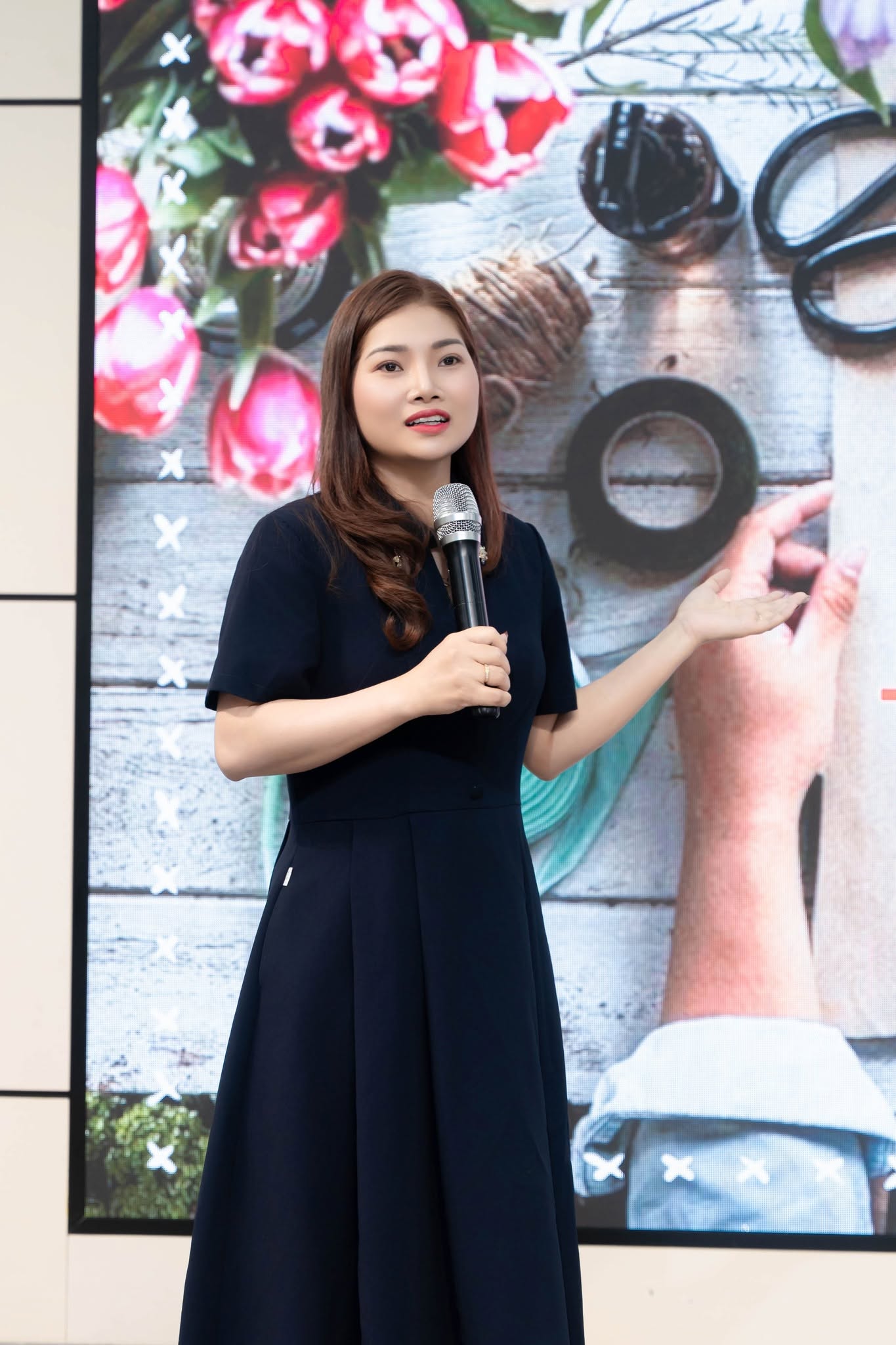 Ms. Hường Maruco cầm micro trong một buổi giảng dạy.